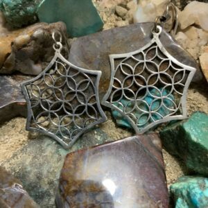 Star-shaped earrings on colorful stones