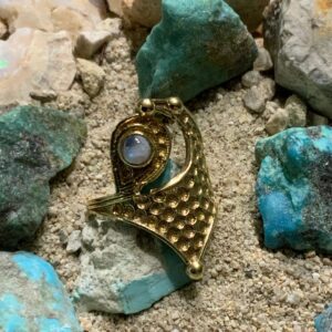 Ornate ring nestled among colorful stones