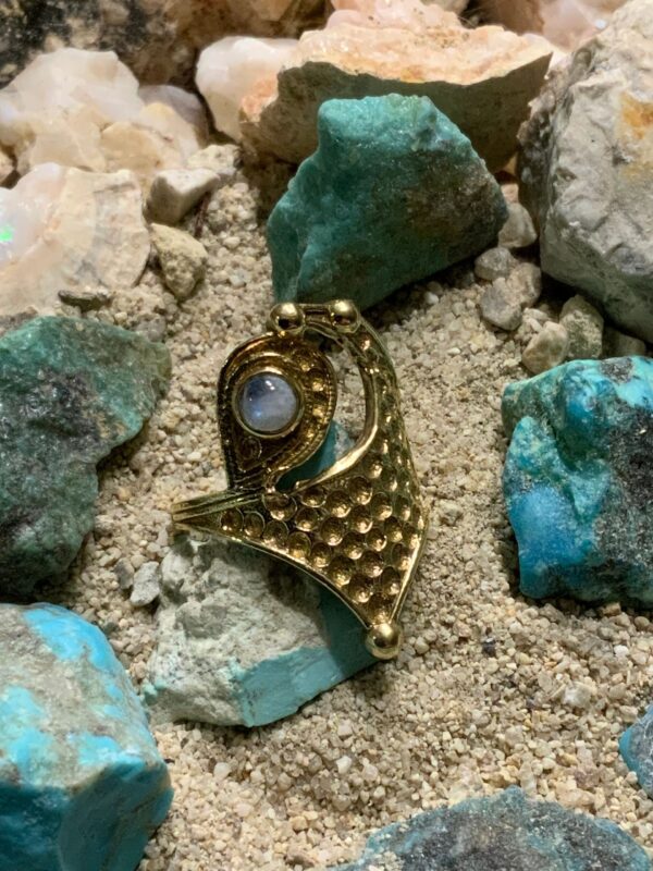 Ornate ring nestled among colorful stones
