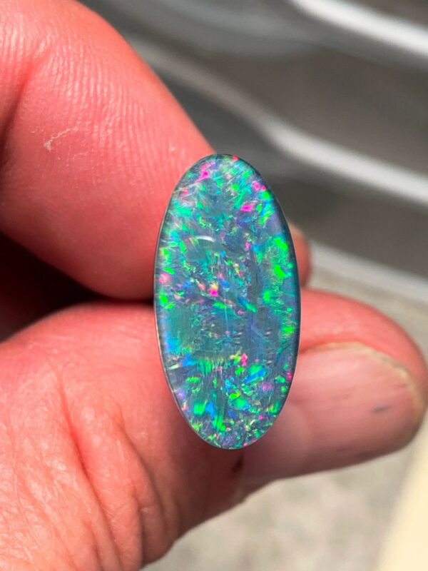 Colorful opal gemstone held by hand