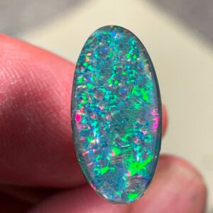 Colorful opal gemstone held by fingers