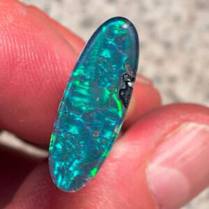 Opal gemstone held between fingers