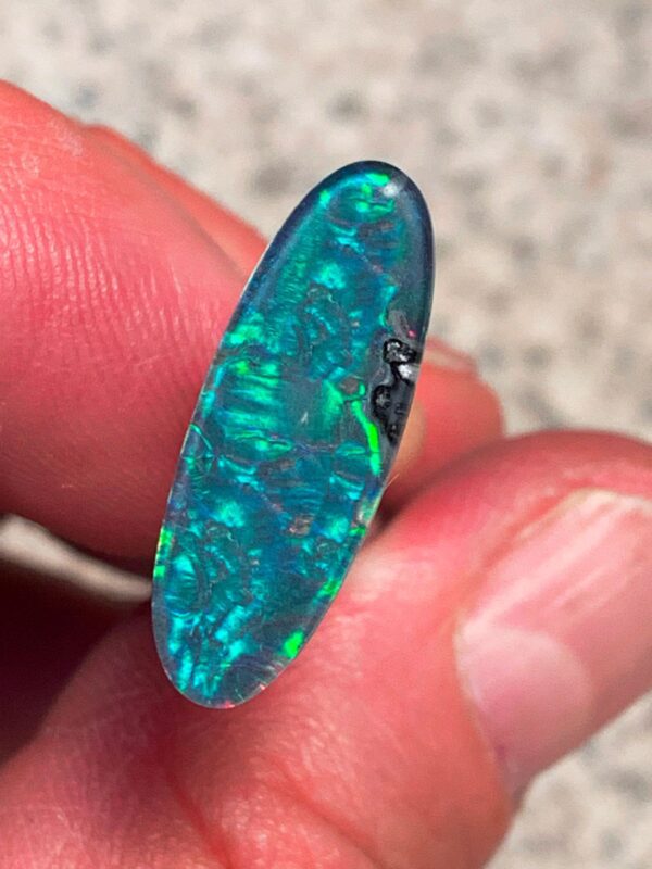 Opal gemstone held between fingers