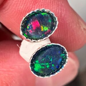 Hand holding two opal stones