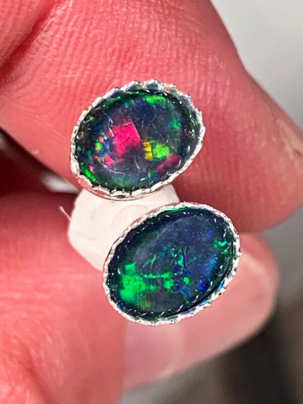 Hand holding two opal stones