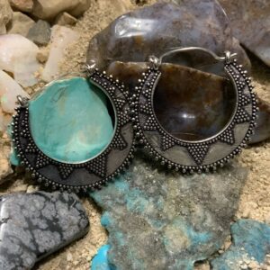 Intricate earrings on rocky background