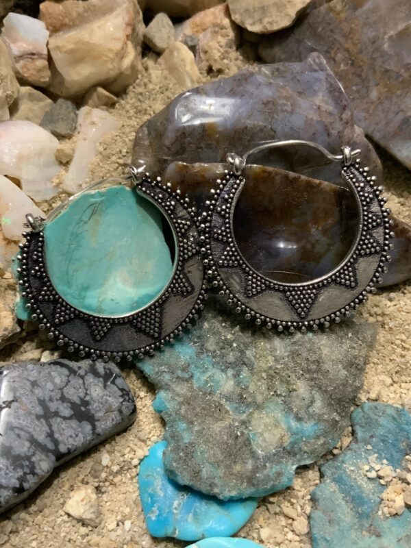 Intricate earrings on rocky background