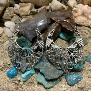 Intricate earrings displayed on stones