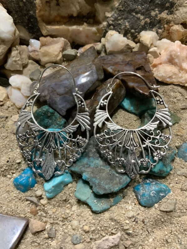 Intricate earrings displayed on stones