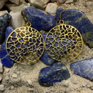 Intricate circle earrings on rocky surface.