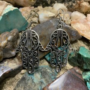 Hamsa earrings on stone background