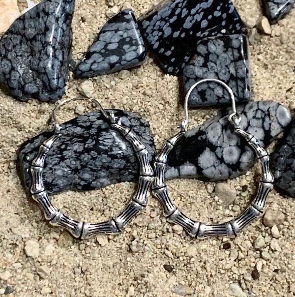 Jewelry displayed on sandy surface with stones