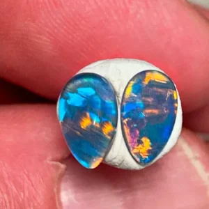Brightly colored opals held between fingers